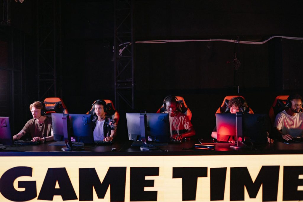 Tuyển thủ thi đấu esport trên sân khấu với hệ thống máy tính và ánh sáng giải đấu